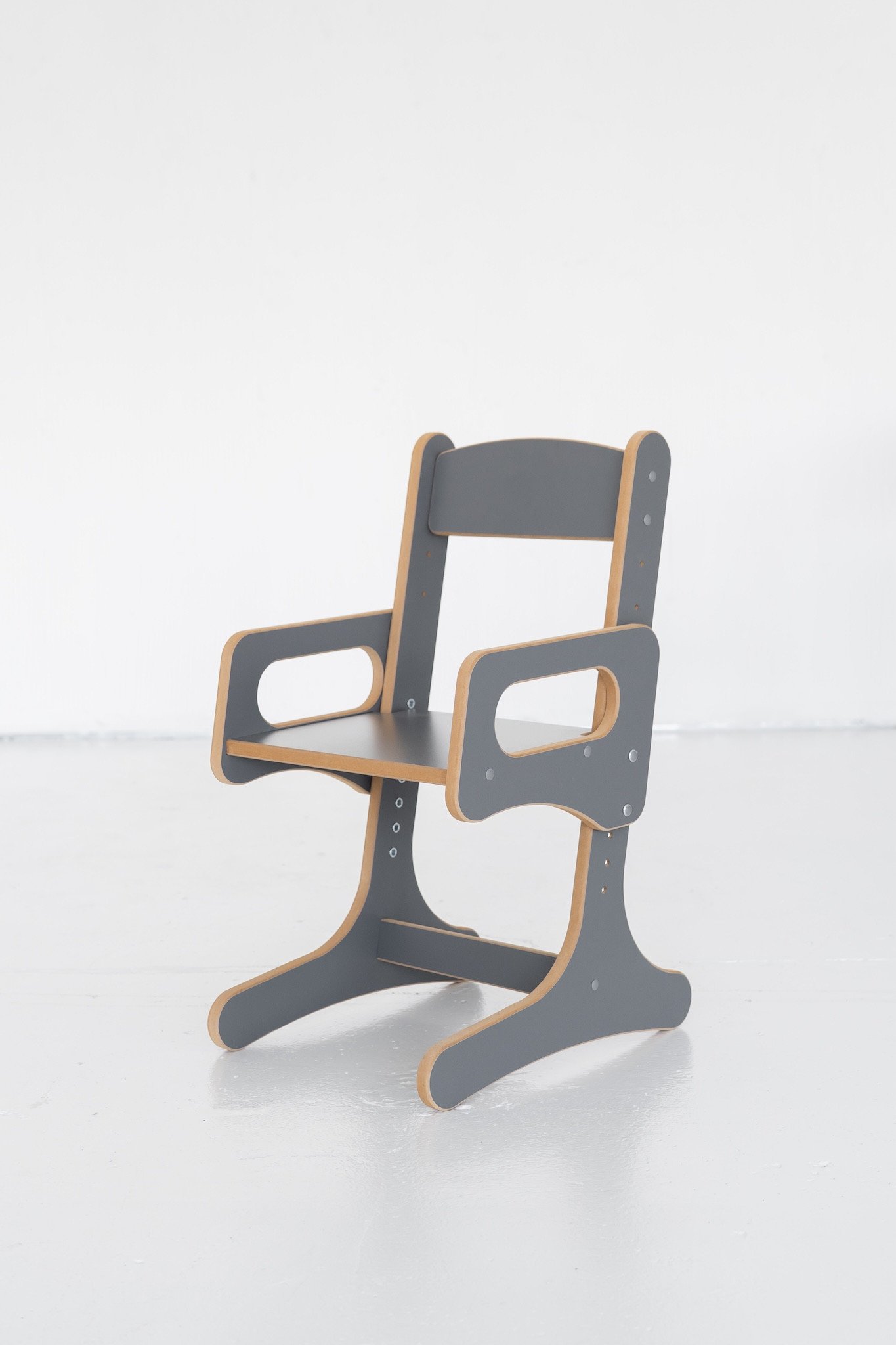 Chaise évolutive pour enfant en bois et métal gris, à faible hauteur, idéale pour favoriser l’autonomie et les premiers gestes. Elle offre accoudoirs et assise stable.